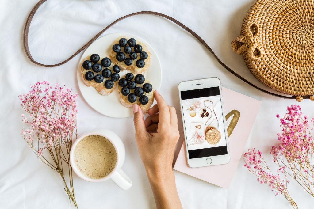 Content for instagram blog. Flat lay of influencer hand holding healthy sandwich
